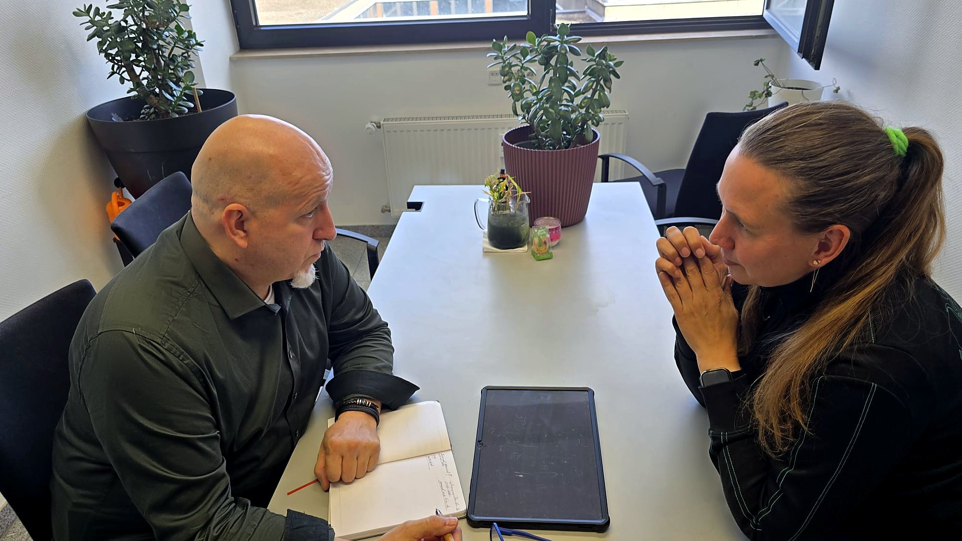 Beratungsgespräch am Tisch, Andreas Gerhardt zeigt Zahlen auf einem Tablet